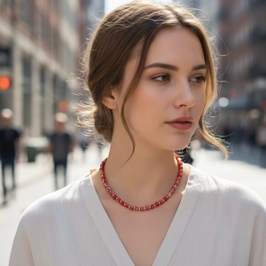 Close-up of handmade beaded necklace with red square stones and silver metal spacers