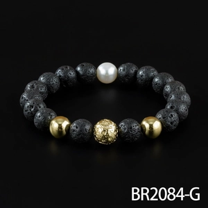 Detailed shot of black lava stone beaded bracelet with golden metal and white pearl accents.