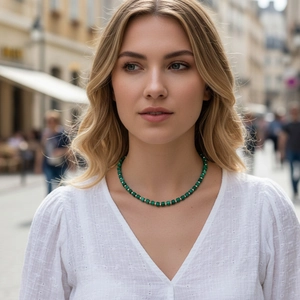 Close-up of green malachite beaded necklace with metallic spacers on a model outdoors