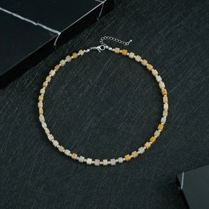 Detail view of square stone beaded necklace with yellow beads and silver metal clasp