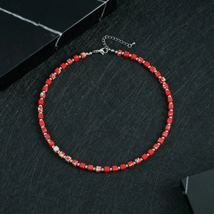 Detail of red square beads and silver spacer beads on a minimalist beaded necklace