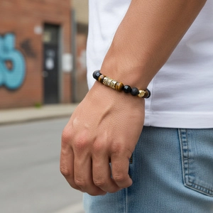Detail of beaded bracelet with tiger eye, lava stone, and pavé zircon crown charm