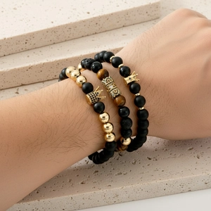 Detail of three-piece men's beaded bracelet set with gold crown and micro-pave zircons
