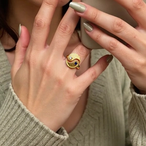 Detail of gold Yin Yang ring with radiating texture and blue and white zircon stones