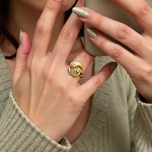 Detail of adjustable gold ring with tai chi spiral design and white zircon insets
