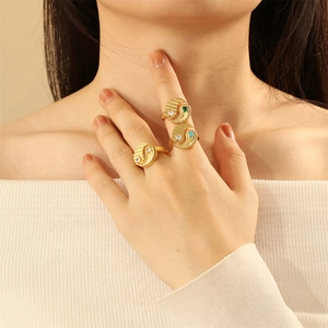 Detailed close-up of gold rings with Tai Chi motif and colorful zircon inlays