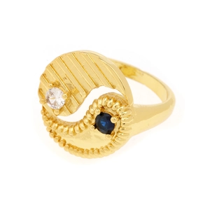 Macro detail of gold Yin Yang ring featuring white zircon and blue gemstone accents