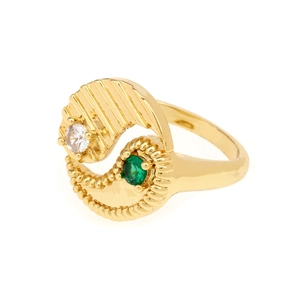 Macro detail of yin yang spiral ring with green gem and white zircon in gold finish
