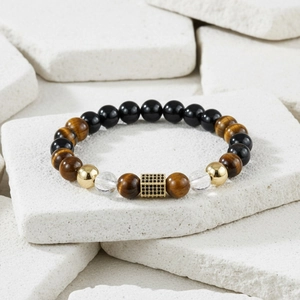 Detail of beaded bracelet featuring tiger eye stone and black zircon cubic charm