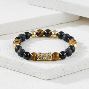 Detail of beaded bracelet featuring tiger eye stone, lava rock, and zircon crown tube