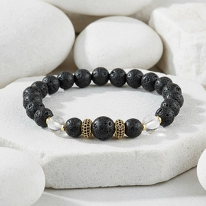 Detail of matte black lava stone beads and gold zircon crown charm on bracelet