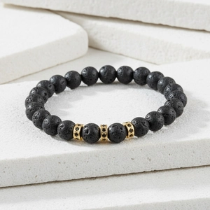 Detail of matte black lava stone beads and gold micro-pave charms on this fashion bracelet