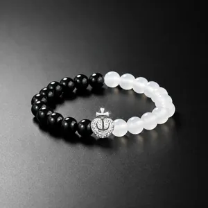 Detail of beaded bracelet with elastic cord, semi-precious stones and anchor heart charm