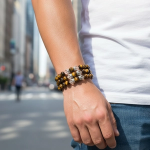 Macro shot of triple-layer tiger eye stone beaded bracelet with silver crown charms