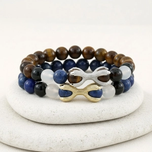 Detail of Lapis Lazuli and Tiger Eye beaded bracelets with pavé set metal charms