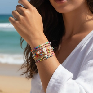 Set di braccialetti boho con margherite e ciondolo malocchio su sfondo spiaggia naturale