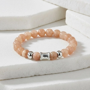Detail of pink stone beaded bracelet with textured silver-toned honeycomb charms and spacers