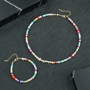 Dettaglio di set di gioielli con perline colorate, perle barocche e chiusura dorata