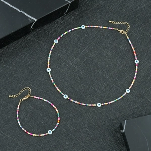 Dettaglio del set di gioielli con perline colorate, ciondoli evil eye e chiusura dorata