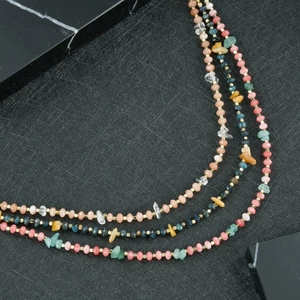 Detail van de handgemaakte kralenketting met natuursteen en gefacetteerde gekleurde kralen