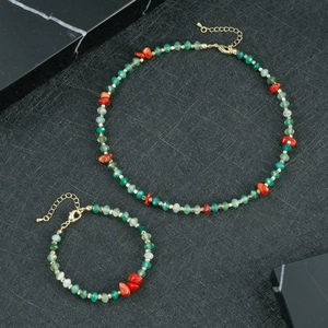Detailweergave van handgemaakte groene facetkralen en rode stenen ketting met gouden sluiting