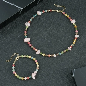 Platliggende set van kleurrijke natuurstenen halsketting en armband met gouden karabijnsluiting