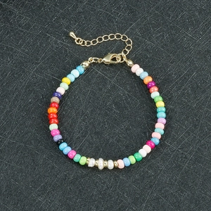 Dettaglio del bracciale di perline colorate con perle irregolari e chiusura d'oro