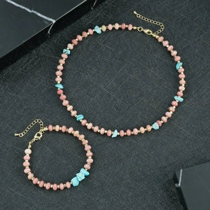 Detailweergave van handgemaakte roze kristallen en turkooizen ketting en armband set