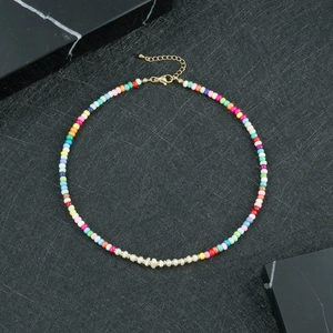 Dettaglio collana bohémien con perline colorate, perle bianche e chiusura dorata