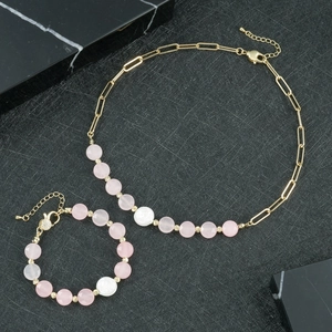 Flachbild von vergoldetem Halsketten- und Armbandset mit rosa Quarzperlen und Perlmutt