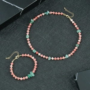 Detail van kralenketting en armband set met roze stenen en groene onregelmatige kristallen