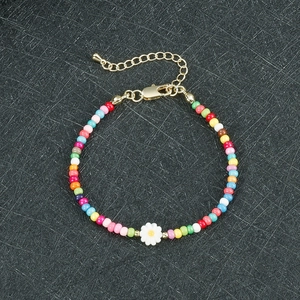 Dettaglio del bracciale di perline colorate con margherita e chiusura dorata regolabile