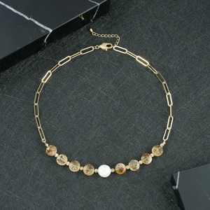 Detail einer Perlenkette mit goldener Büroklammerkette und gelben Kristallperlen