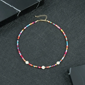 Dettaglio della collana bohémien colorata con margherite bianche e chiusura dorata