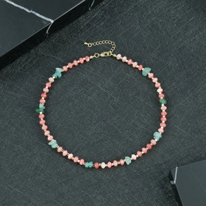 Detailopname van handgemaakte kralenketting met roze kralen en groene onregelmatige stenen