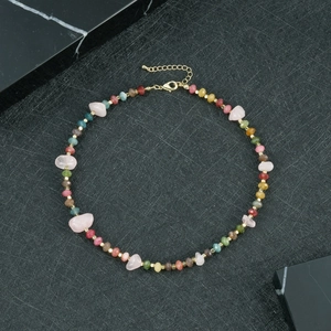 Detailopname van een kleurrijke natuurstenen kralenketting met gouden metalen accenten