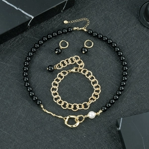 Vue détaillée de l'ensemble de bijoux onyx avec chaînes dorées et accents de perles