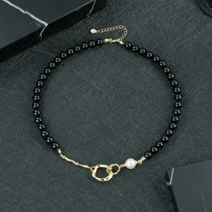 Détail du collier d'onyx noir avec perle blanche et fermoir doré ajustable de luxe