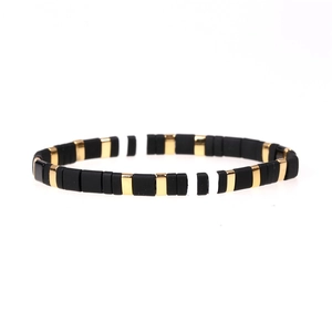 Enamel Tila bead stretch bracelet in matte black, polished gold, and white color combination