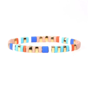 Detail of multi-color enamel tile beads and golden metal spacers on elastic bracelet