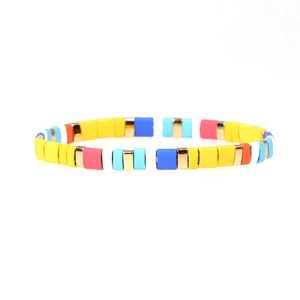 Detailed view of colorful enamel tila bead stretch bracelet with gold metallic spacers