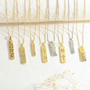 Close-up of gold and silver rectangle pendants with micro-pave zircon stars and LOVE letters