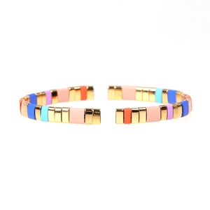 Detail of bohemian colorful tila bead bracelet with gold metal accents and enamel finish
