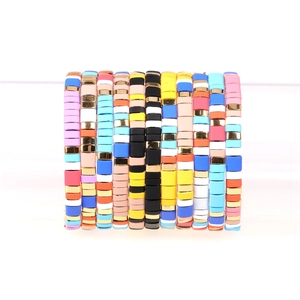 Detail of 10 colorful Heishi bead bracelets with gold accents on a display stand