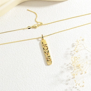 Close-up of golden LOVE pendant necklace with multi-colored cubic zirconia and lobster clasp