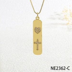 Macro detail of gold bar pendant necklace with pavé zircon heart and cross motifs