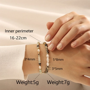 Detailweergave van gelaagde zoetwaterparel en halfedelsteen armbanden bij een model