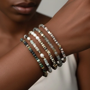 Detailopname van bohemian armbanden met zoetwaterparels en gouden geometrische kralen