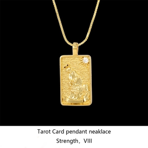 Macro detail of gold tarot card necklace featuring Strength VIII pendant with crystal