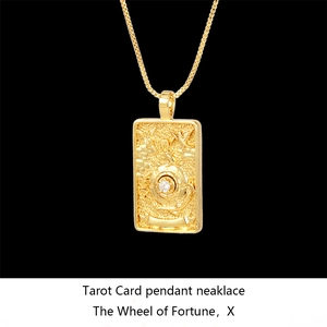 Macro shot of gold Wheel of Fortune tarot pendant necklace with high relief detail